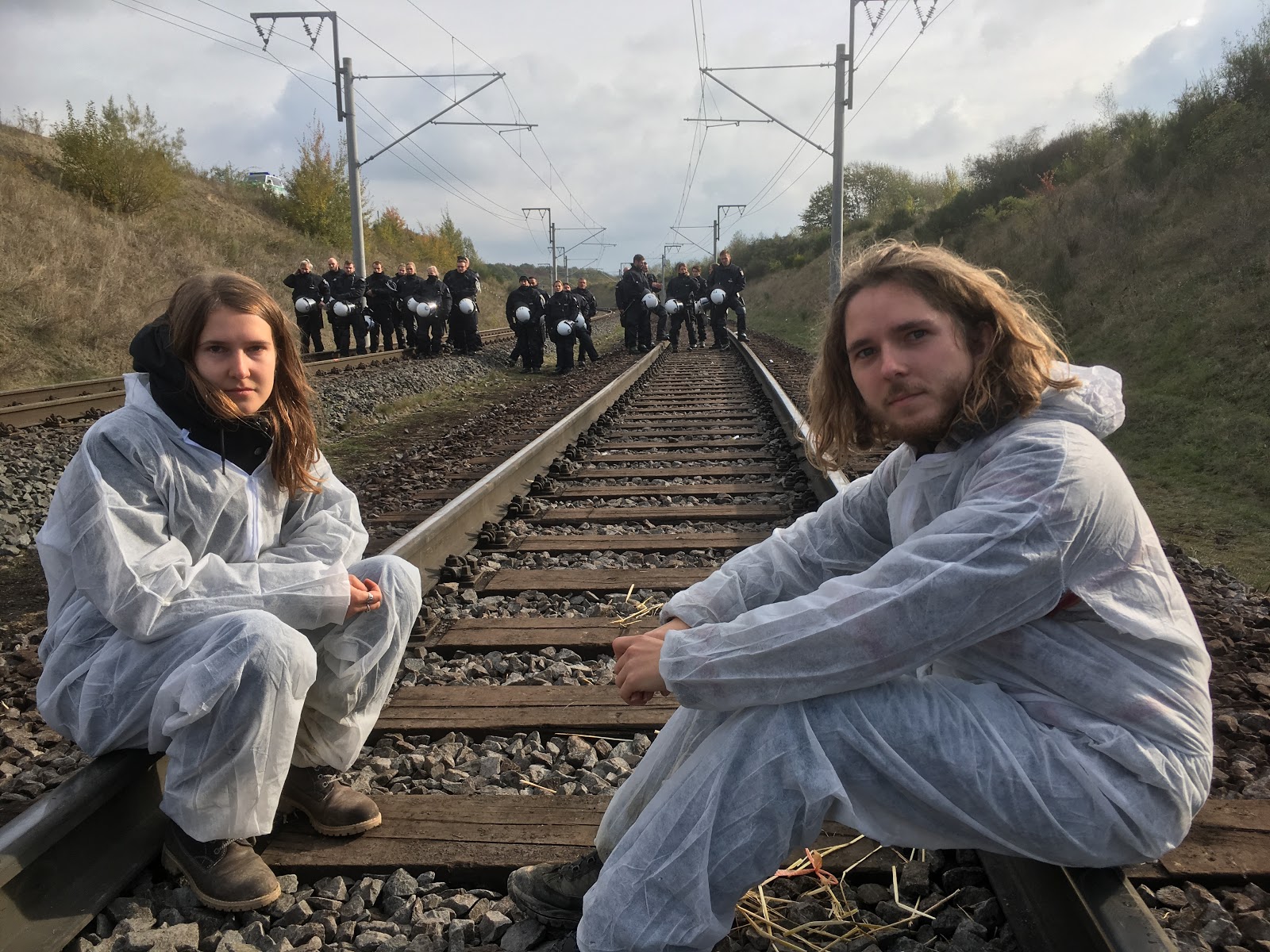 Sofie en Herman op de rails met politie op de achtergrond